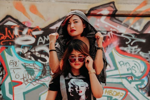 Girls in Casual Wear Posing on Graffiti Wall