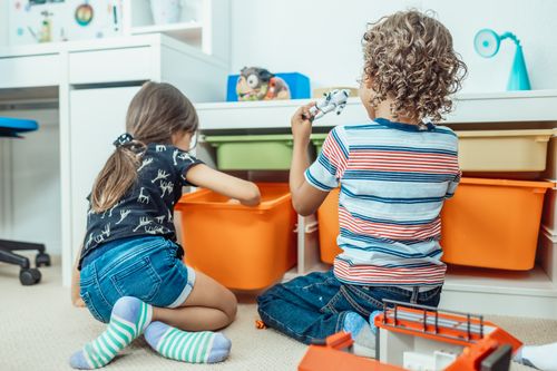 Free Two kids playing with toys and colorful bins in a playful indoor setting. Stock Photo