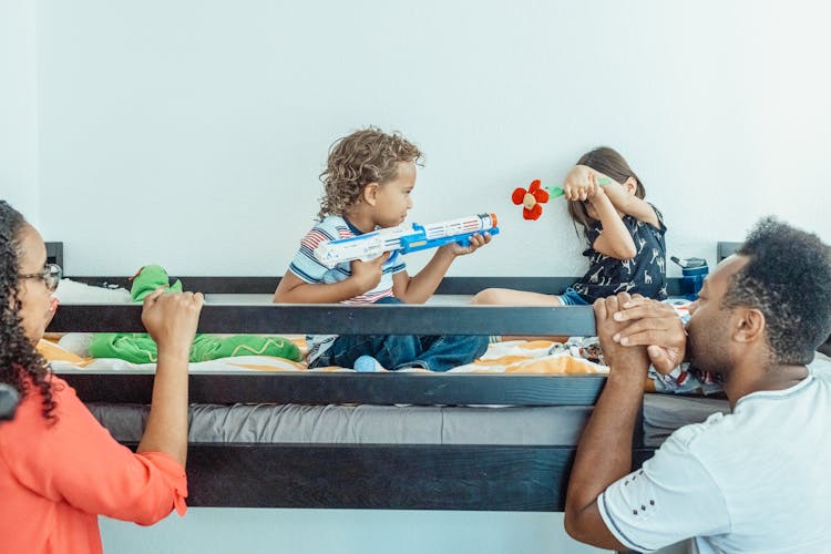 A Boy And A Girl Playing On A Bunk Bed