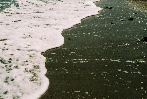 Free Relaxing scene of ocean waves gently washing over a sandy beach, creating a calming seascape. Stock Photo