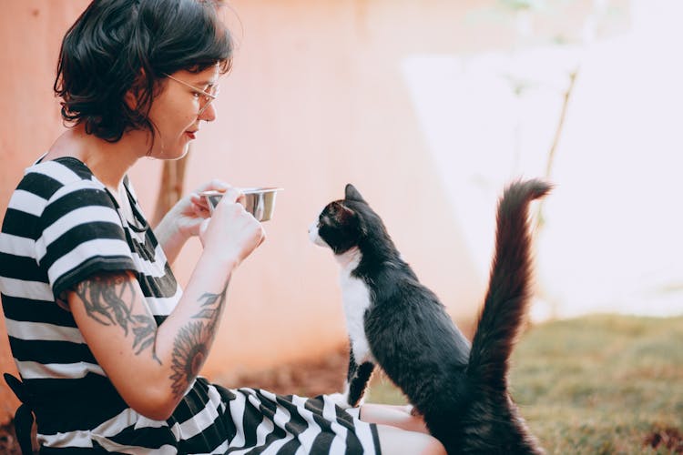 A Woman Holding A Cat Feeder