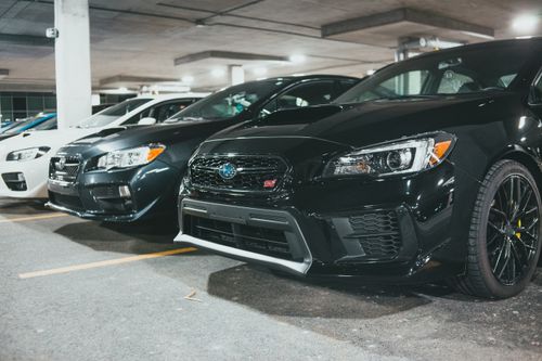Free A row of parked Subaru cars in an indoor parking garage, showcasing modern automotive design. Stock Photo