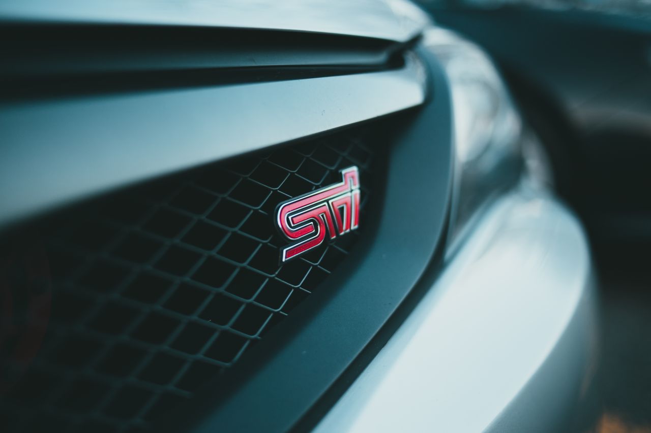 detail shot of a sports car grille featuring a metallic logo showcasin