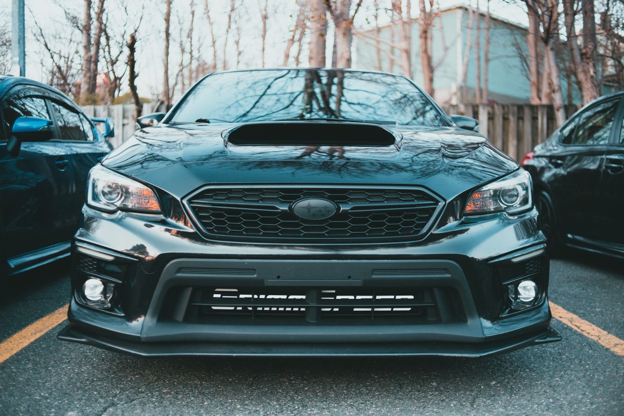 a sleek black subaru impreza with a prominent hood scoop captured in a