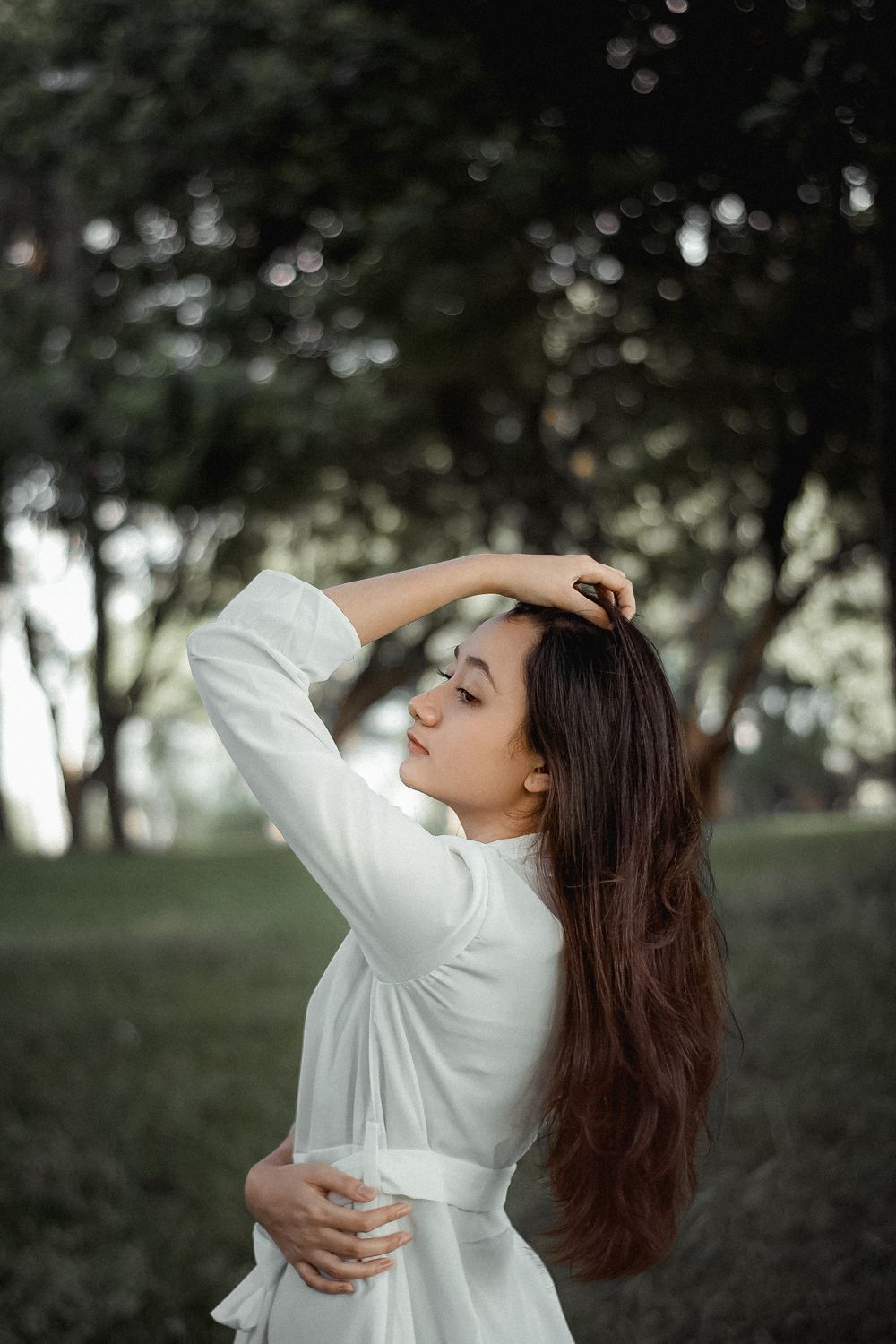 Young Brunette Woman in White Dress and Holding Her Hand in Hair · Free ...