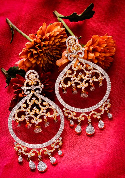 Free Exquisite diamond earrings set against a vibrant red background paired with blooming dahlias. Stock Photo