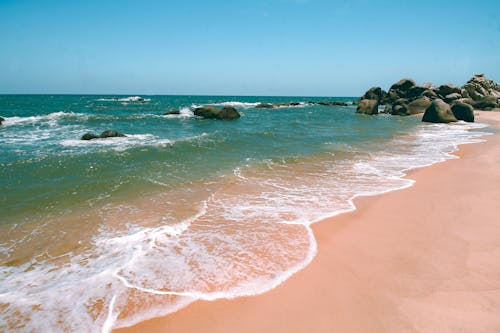 Foto profissional grátis de areia, beira-mar, borrifando