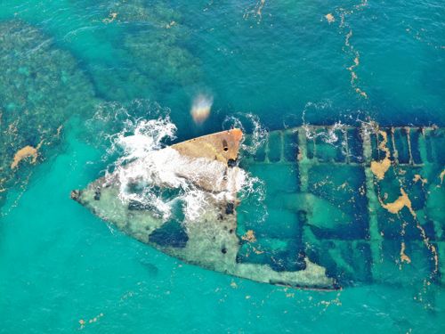 Free Explore the mysterious remnants of a sunken ship in the vibrant blue waters of the Dominican Republic from above. Stock Photo