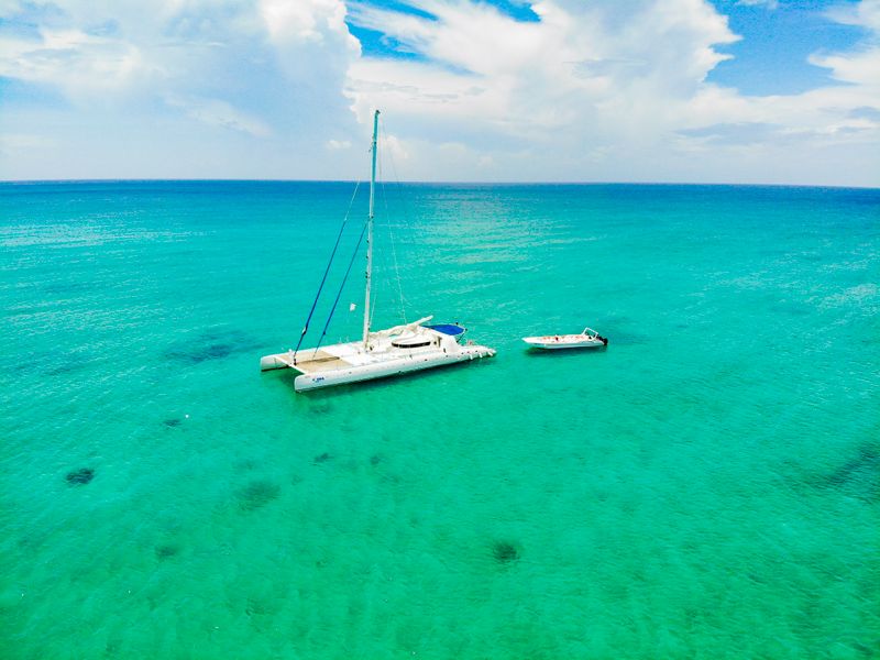 Catamaran sailing in turquoise Caribbean water under a blue sky