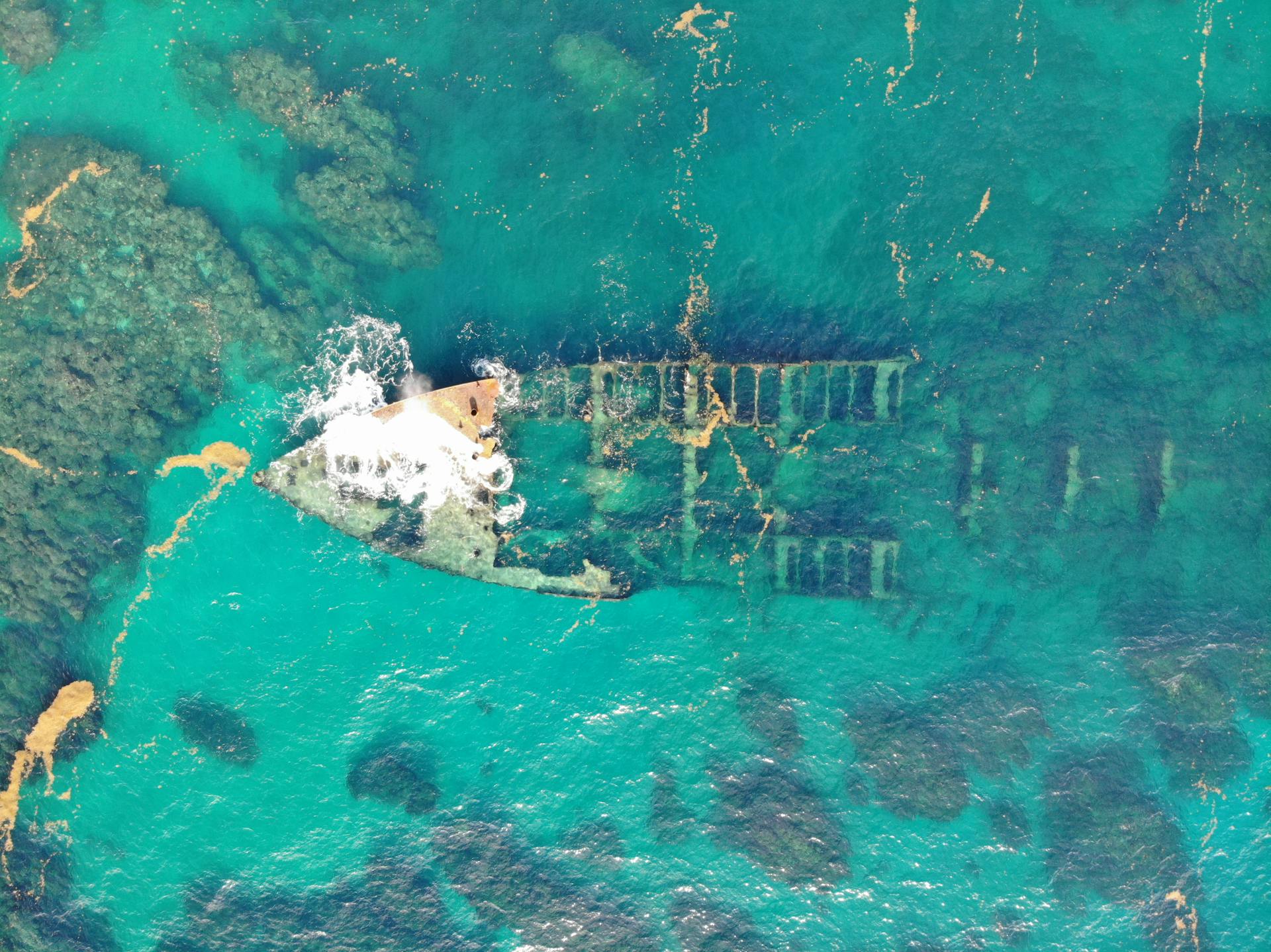 Aerial drone shot of a sunken shipwreck visible beneath the sea off the Dominican Republic coast.
