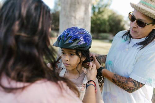 A Young Girl Wearing a Blue Bicycle Helmet