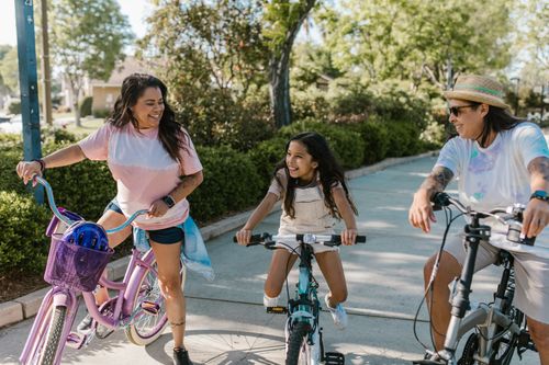Free Happy family enjoying a leisurely bike ride in a sunny park, showcasing bonding and togetherness. Stock Photo