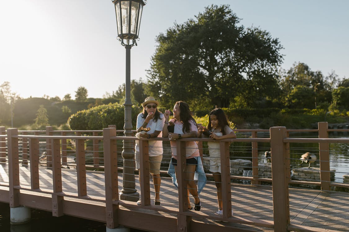 A Family Eating Snacks while Leaning on a Railing