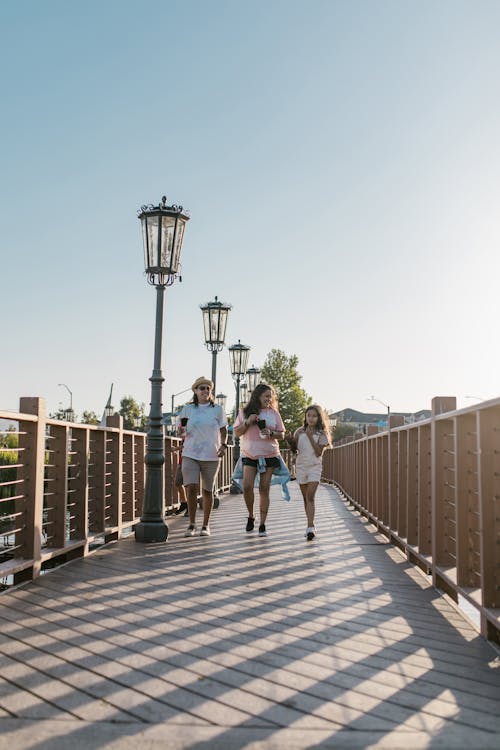 A Family Holding Snacks while Walking on a Footbridge