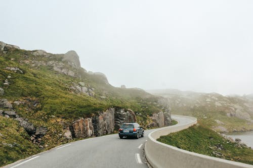 Car driving on road among rocky mountains