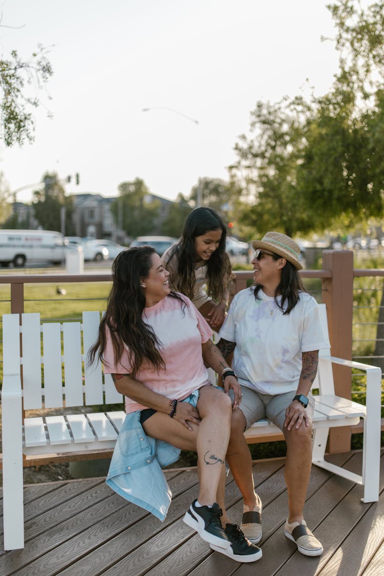 A Family Sitting On The Park Bench