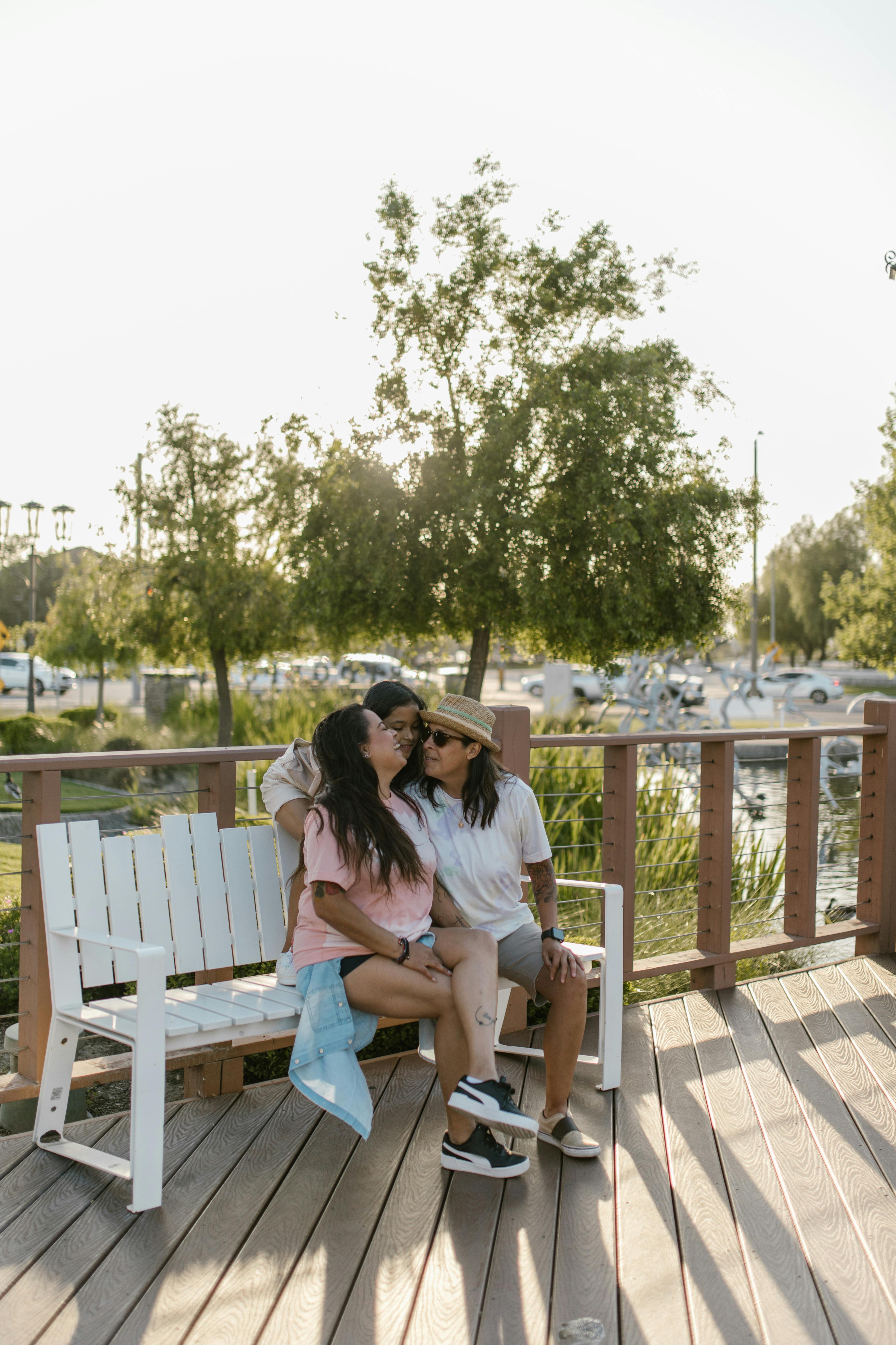 A cheerful family sitting together on a park bench, embracing the moment under a sunny sky.