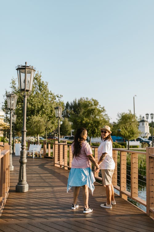 Women Walking on a Bridge and Holding Hands 