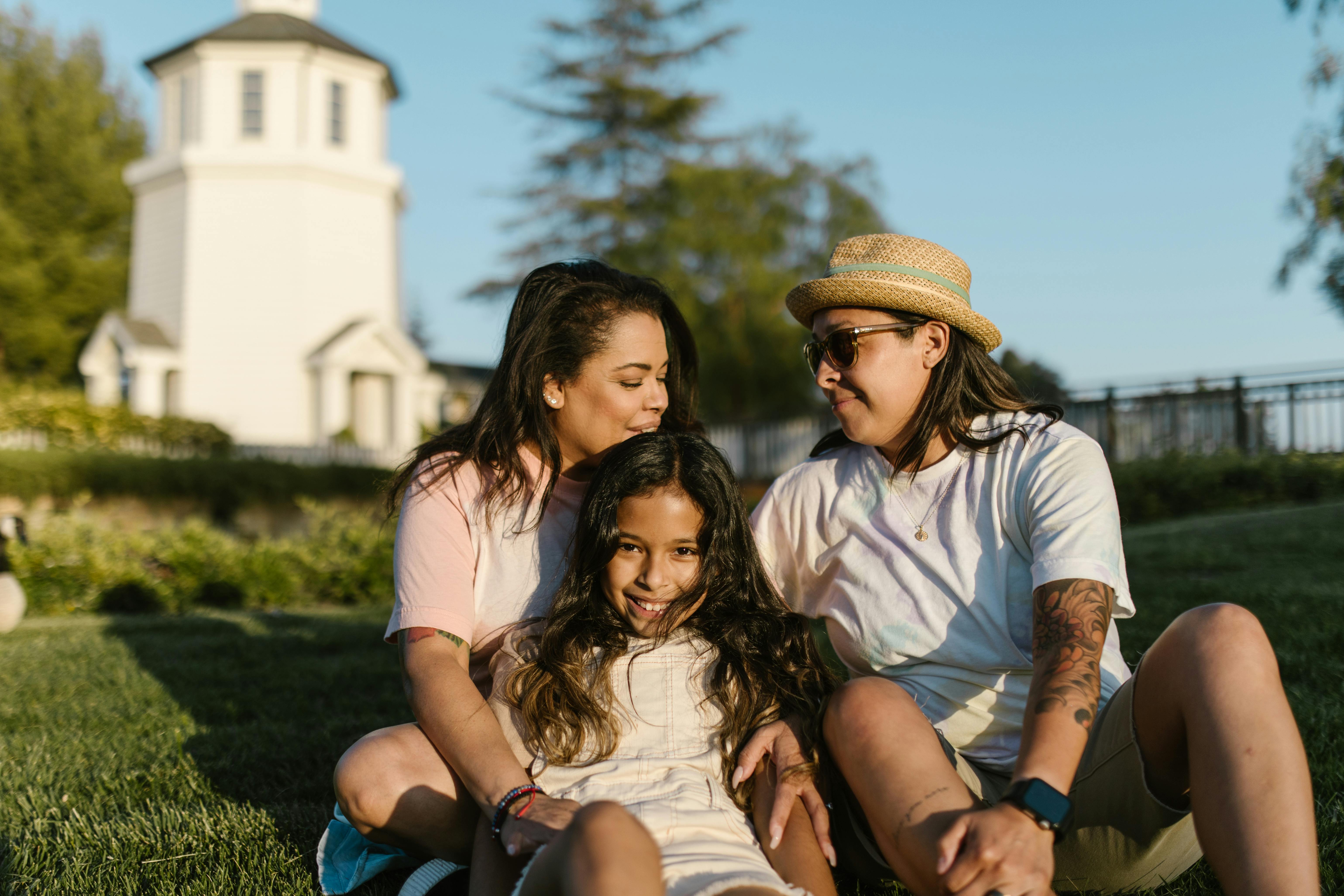 family sitting on the grass together