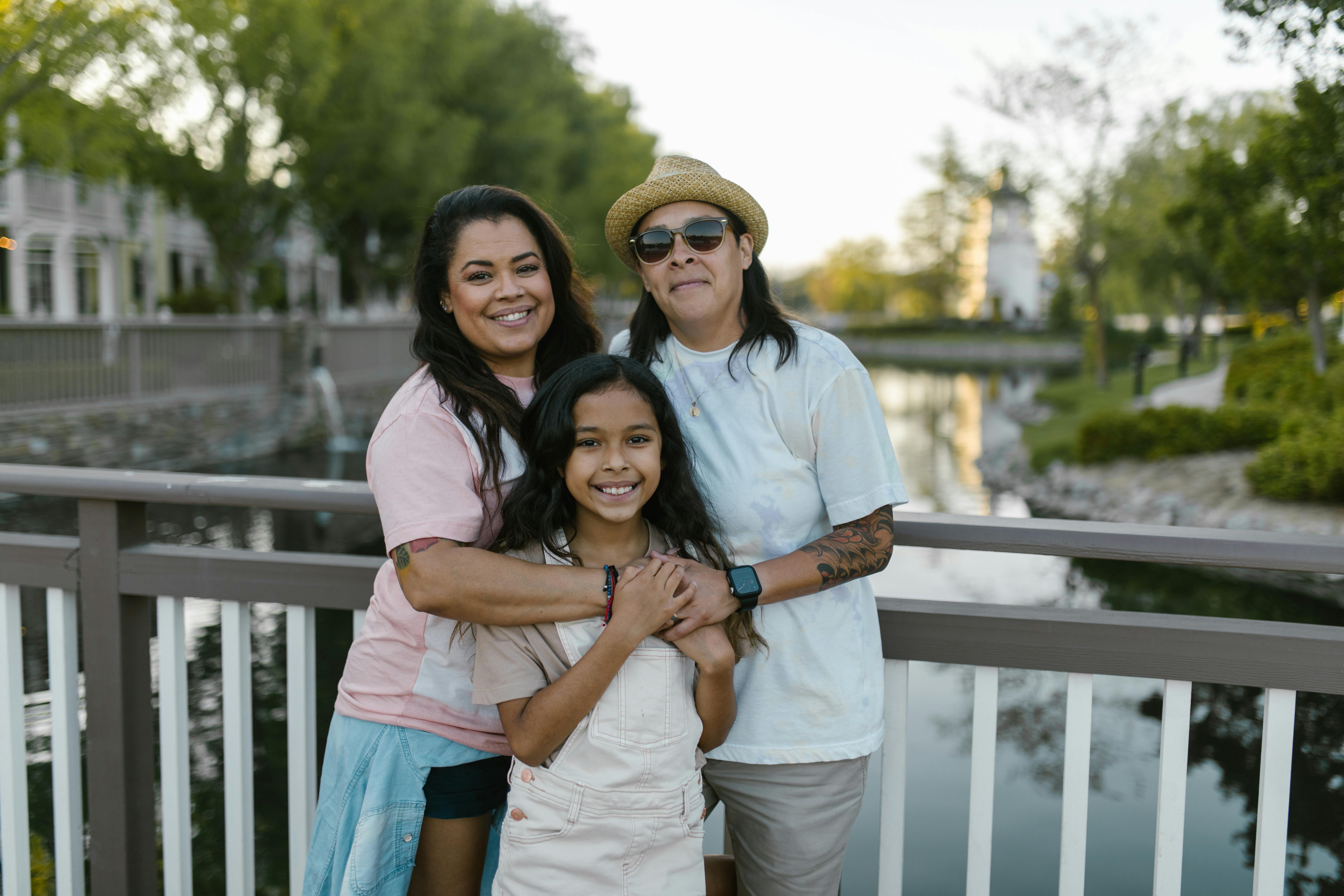 a family leaning on metal railings near a body of water