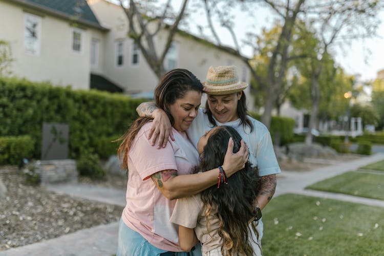 Family Hugging In Front Of A House 