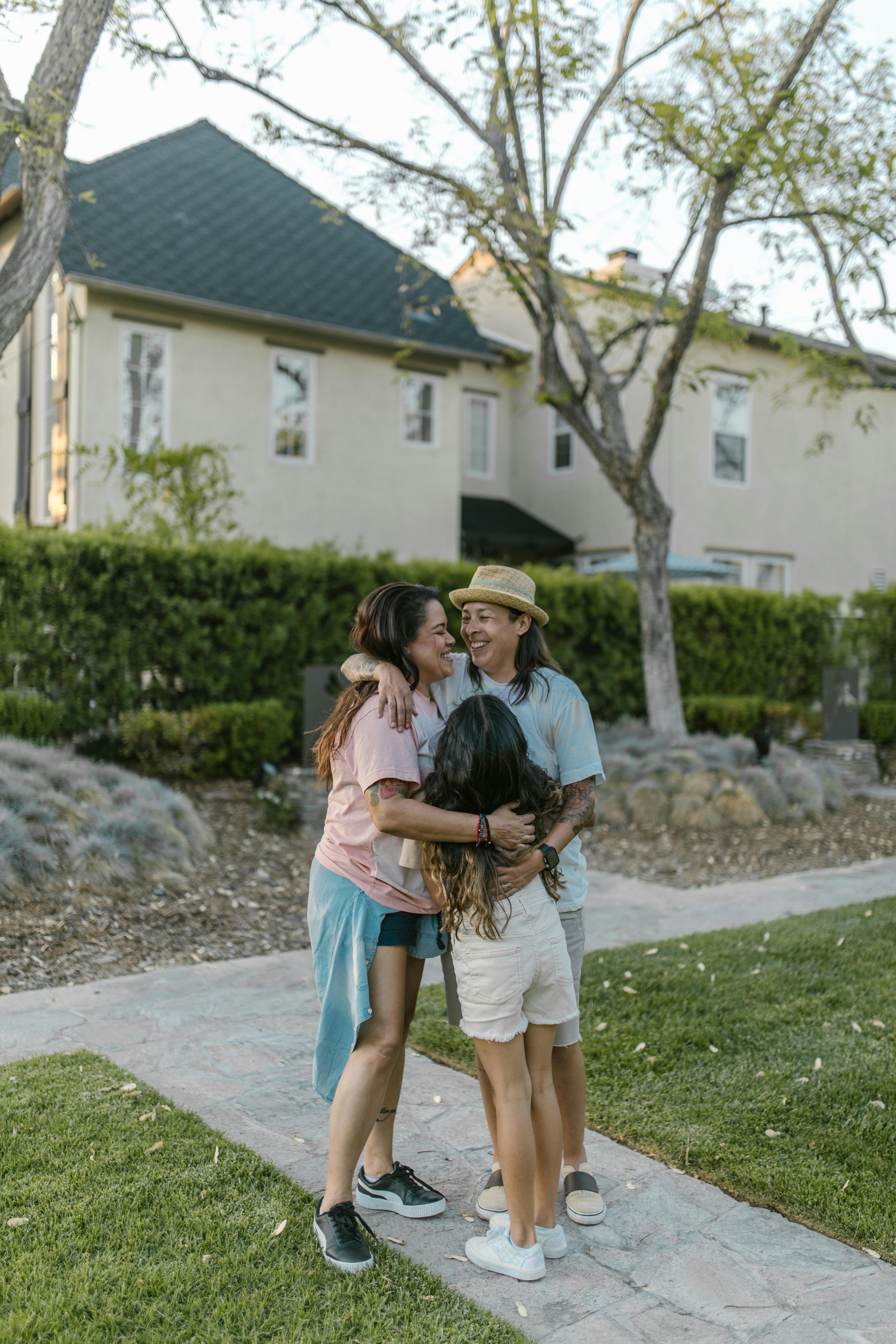 mother and daughter standing on the pavement and hugging