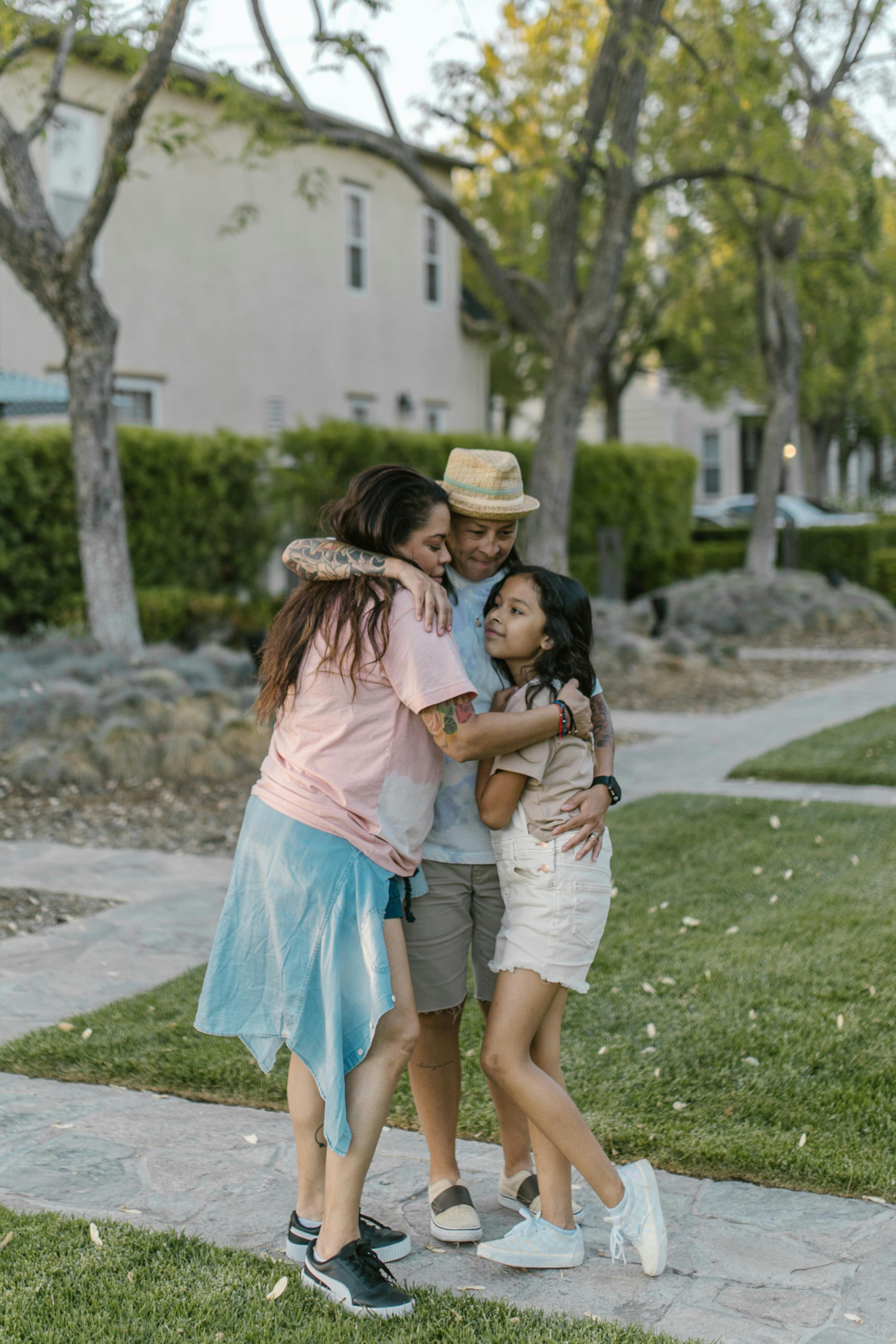 mother and daughter standing on the pavement and hugging