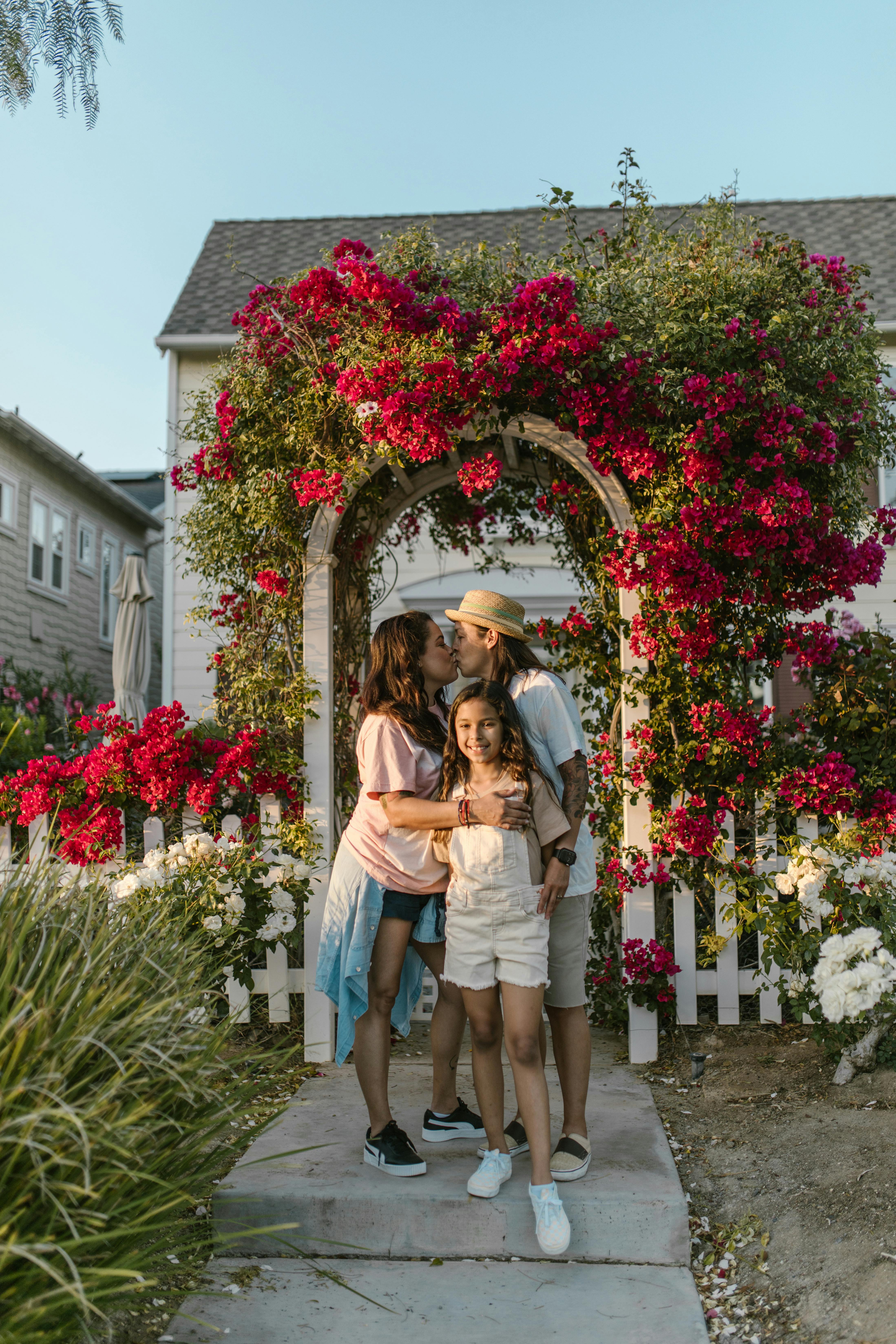 women kissing and hugging their daughter in a garden