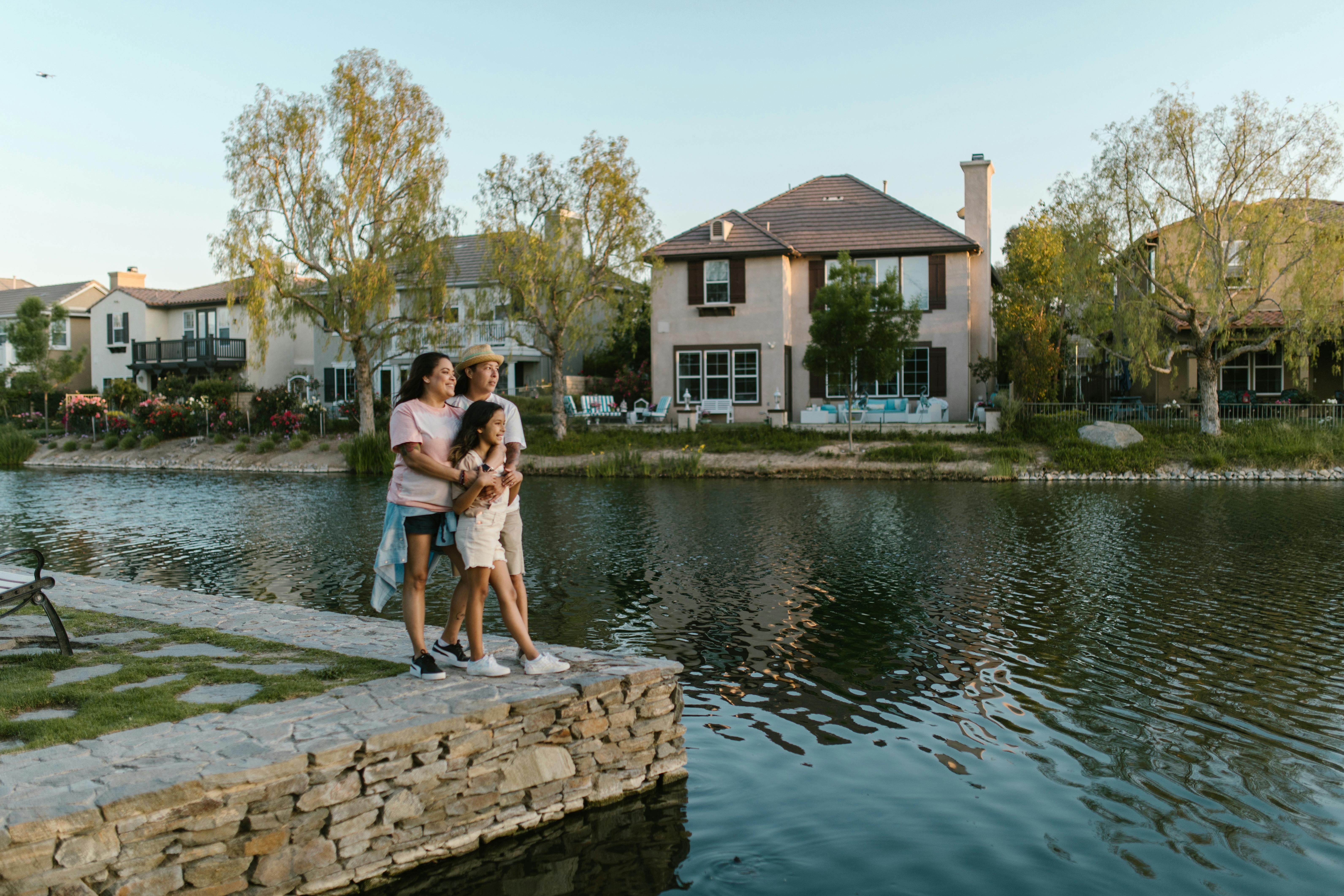 mothers and daughter embracing and standing by a body of water