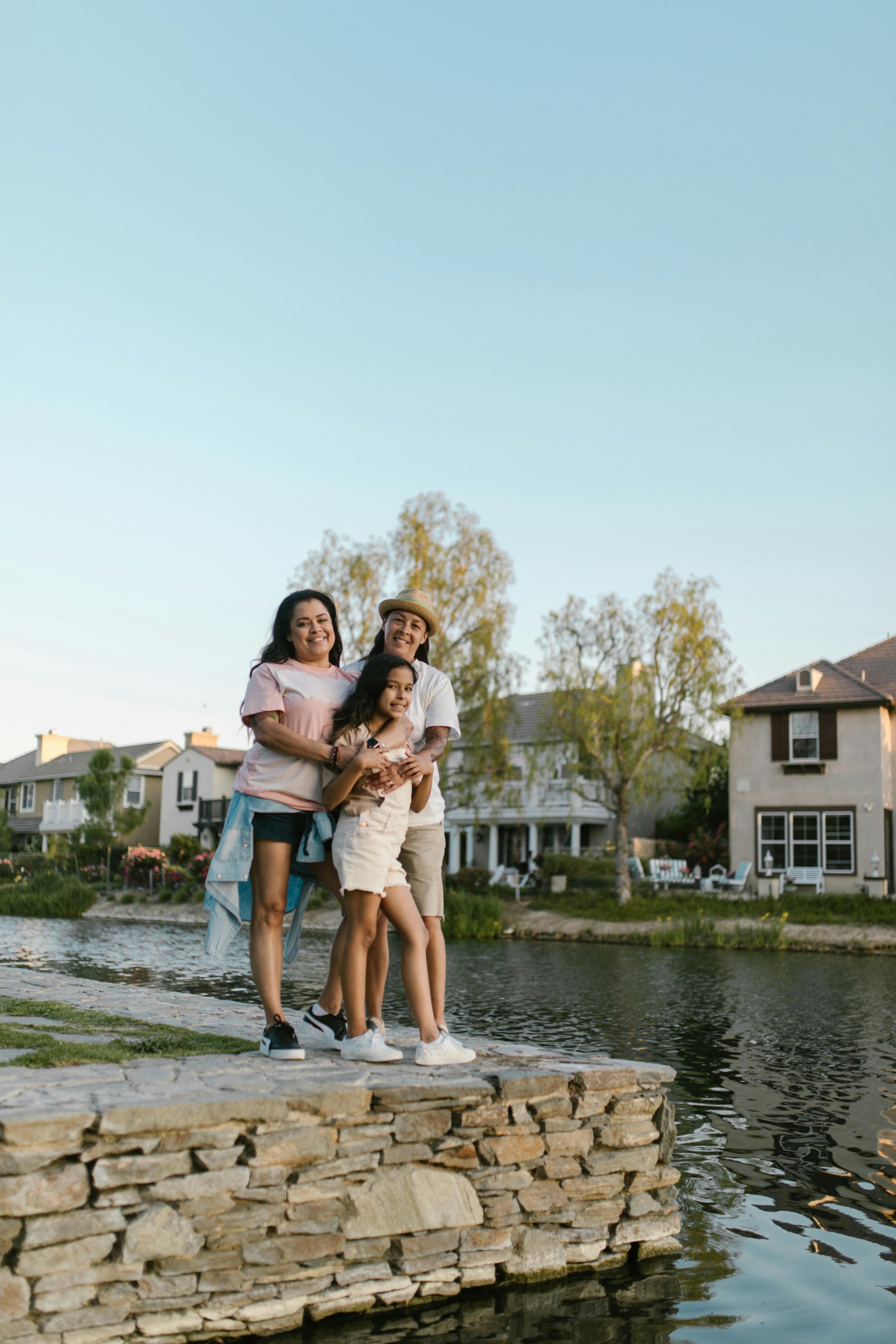 mothers and daughter standing by a body of water and smiling