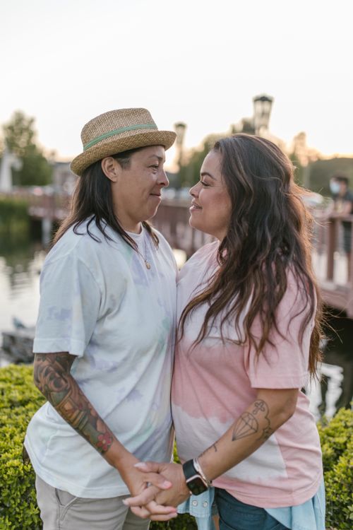 Free Lesbian couple embracing outdoors at sunset, showcasing love and connection. Stock Photo
