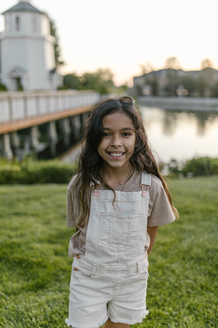 A Happy Little Girl In A White Jumper