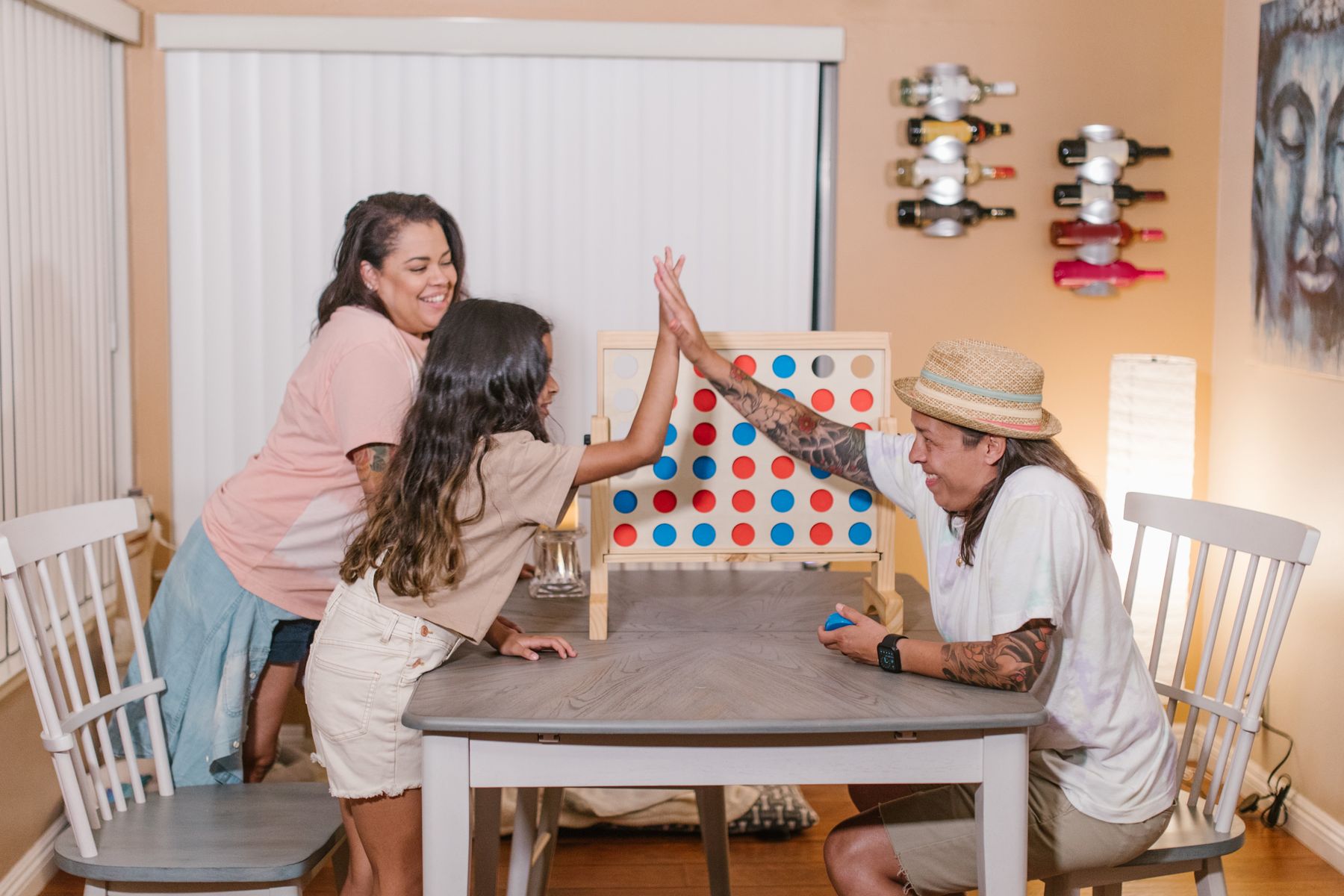 A family smiling and playing a colorful tabletop game together