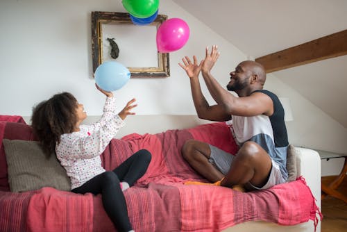 Free 
A Father and Daughter Playing with Balloons Stock Photo