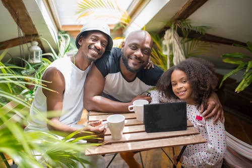 A Happy Family Sitting Near the Wooden Table