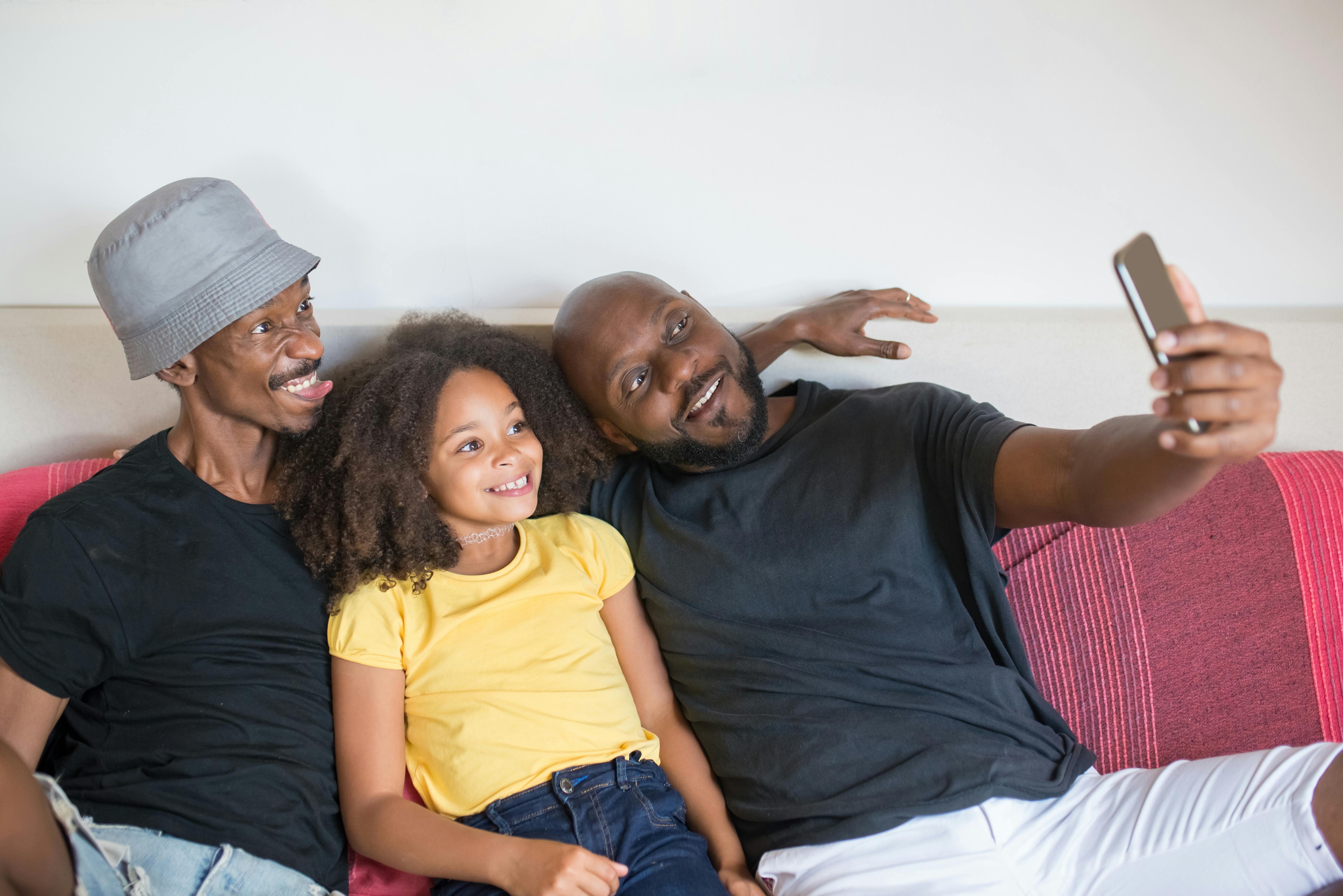 a man taking selfie with his family while sitting on the couch