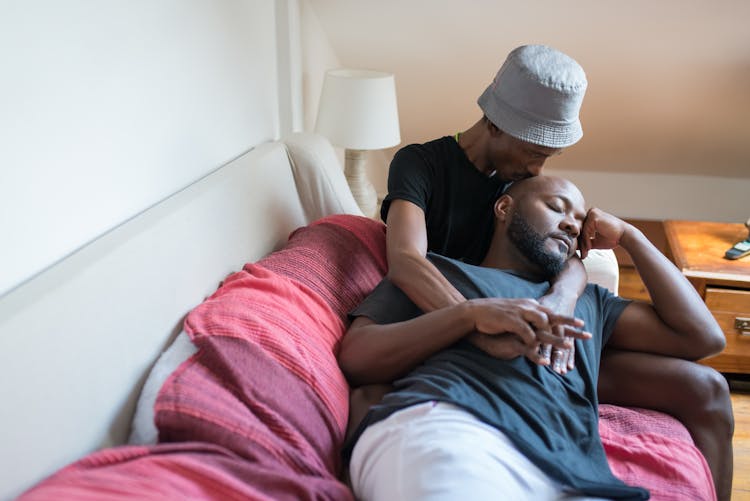 A Couple Sitting And Lying On A Sofa