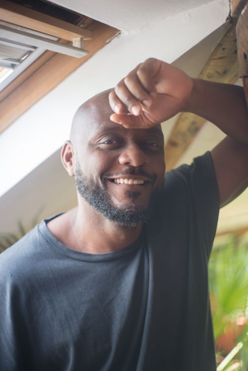 Free Smiling man poses indoors near window, exuding warmth and happiness. Stock Photo