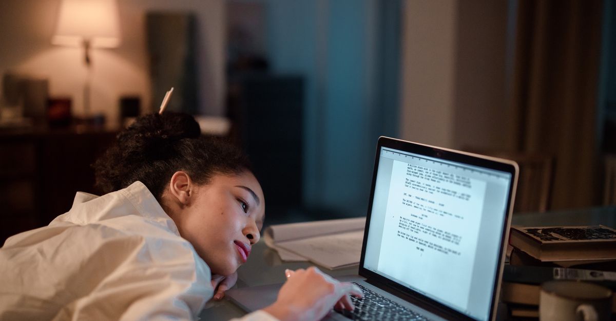 student using laptop studying at night