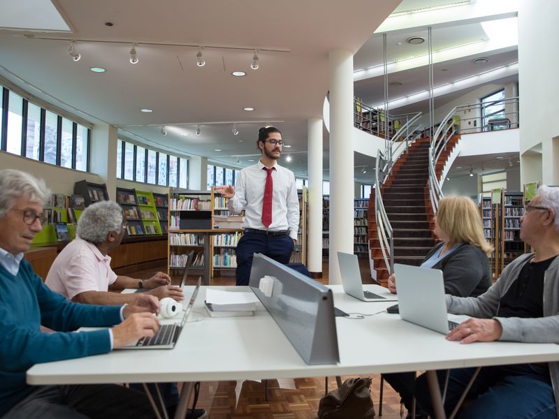 Team engaged in a collaborative meeting in a modern library setting - library local history programs