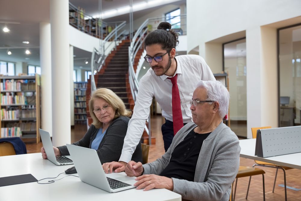 Formateur expliquant l'informatique à un groupe de seniors