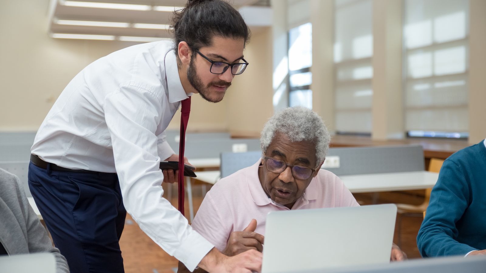Formateur accompagnant une personne devant un ordinateur