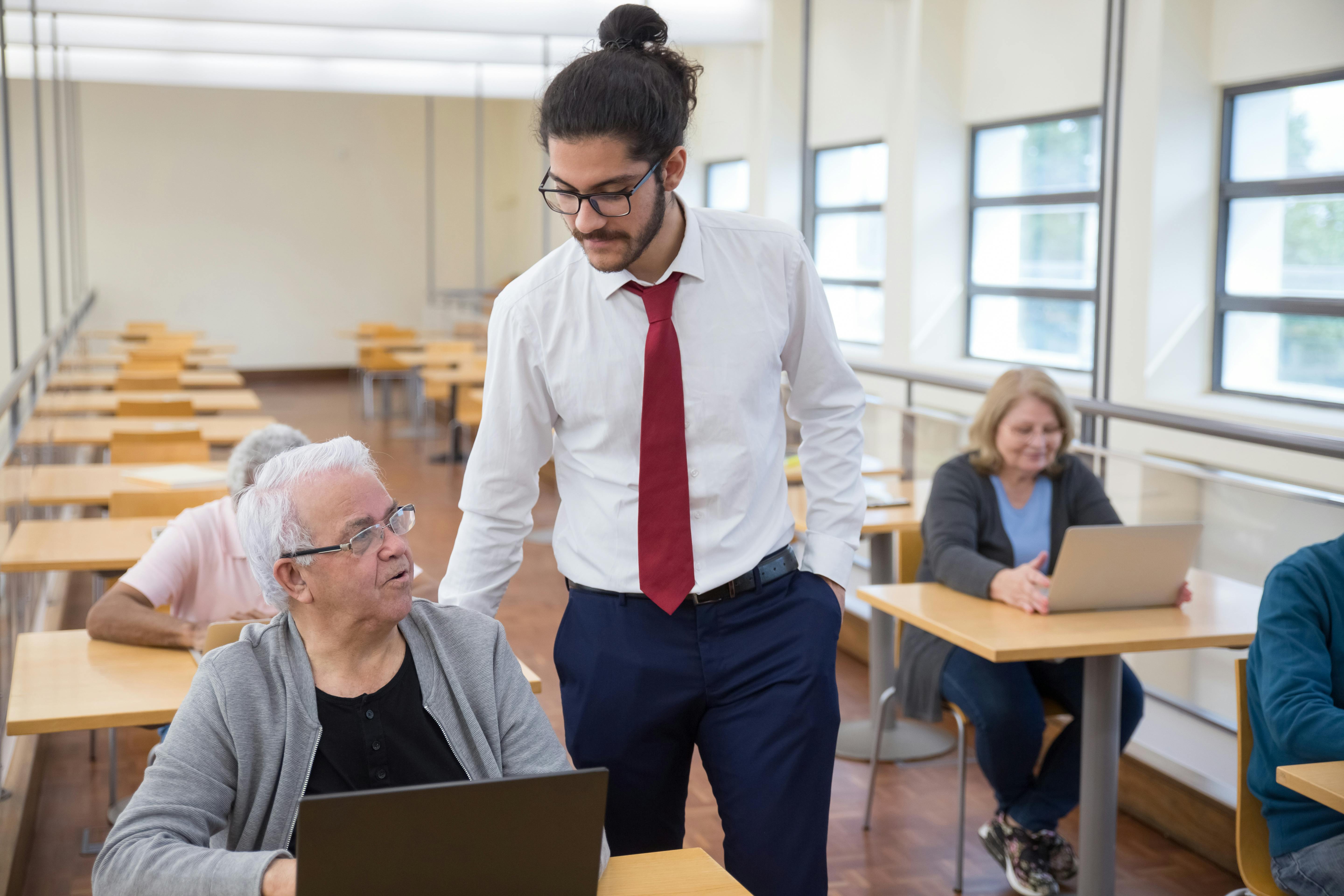 Group of seniors learning computer skills in a Portugal classroom setting.