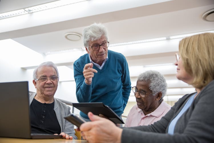 Group Of Elderly Men Discussing Beside A Woman