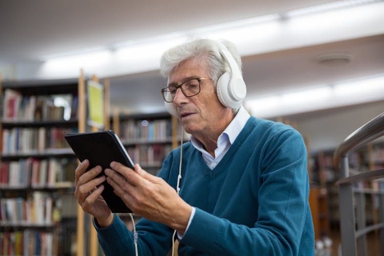 An Elderly Man Watching On A Digital Tablet