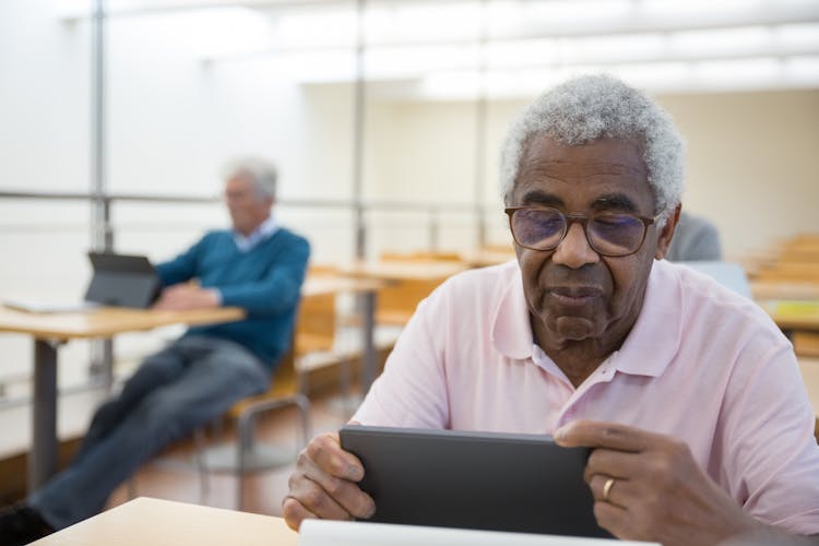 An Elderly Man Using A Tablet