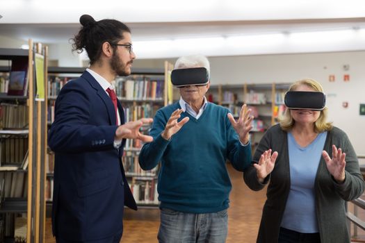 Elderly couple experiencing virtual reality in a modern library setting.