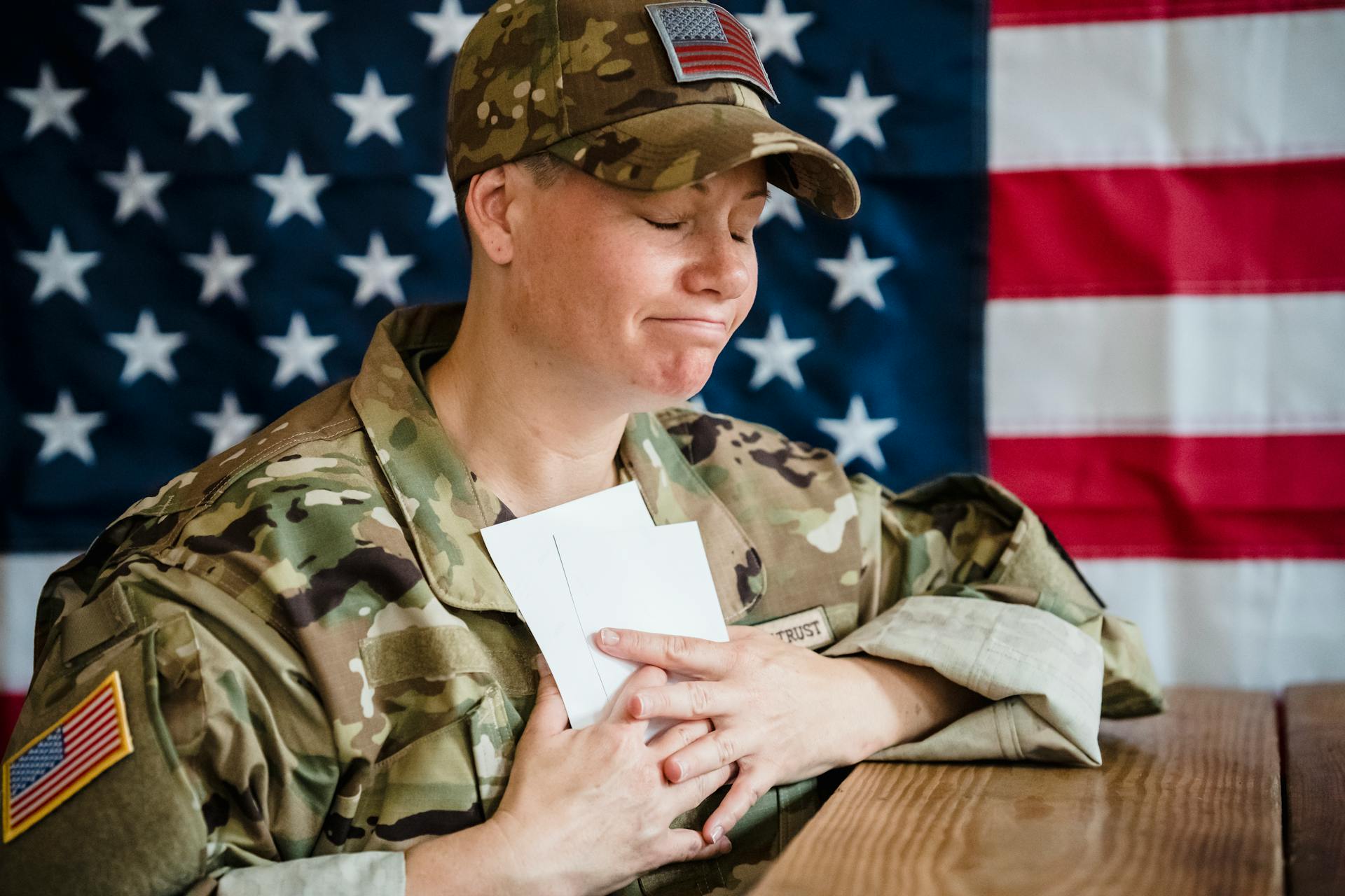 Woman in a Military Uniform Hugging Pictures of Her Family