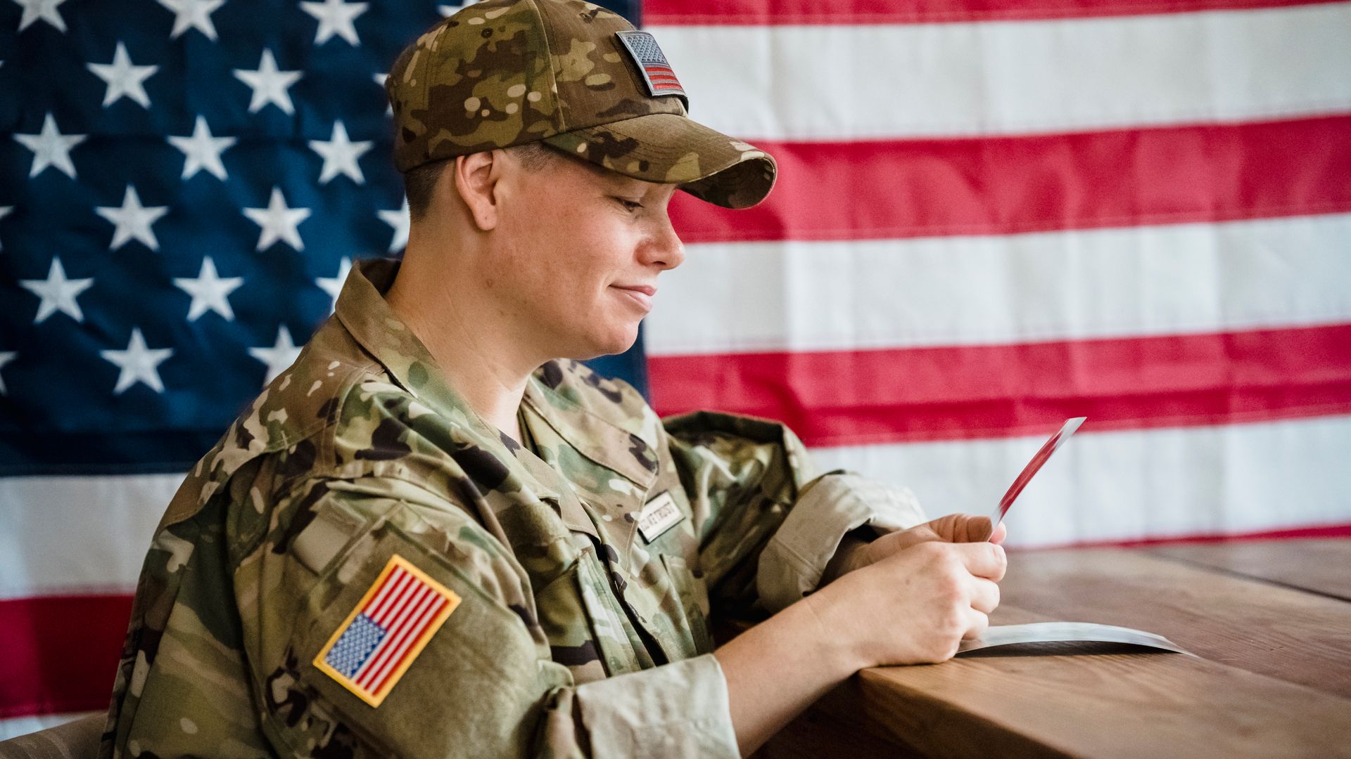 Modafinil for Military Personnel: Enhancing Performance and Alertness Soldier in uniform with US flag background, reflecting on memories — modafinil for military personnel