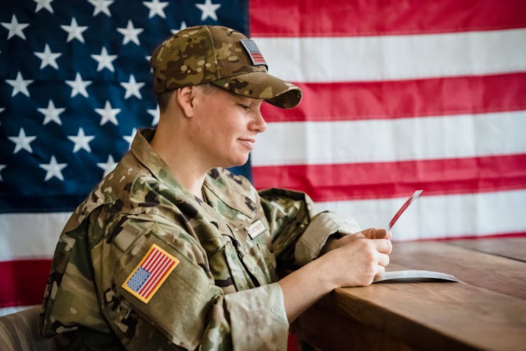 US Army Soldier Looking Wistfully At Photographs 